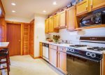 Fully applianced galley kitchen with breakfast bar.